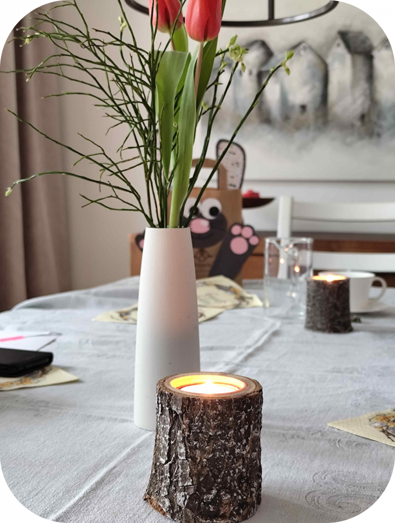 Teelichthalter aus Holz vor Blumenvase